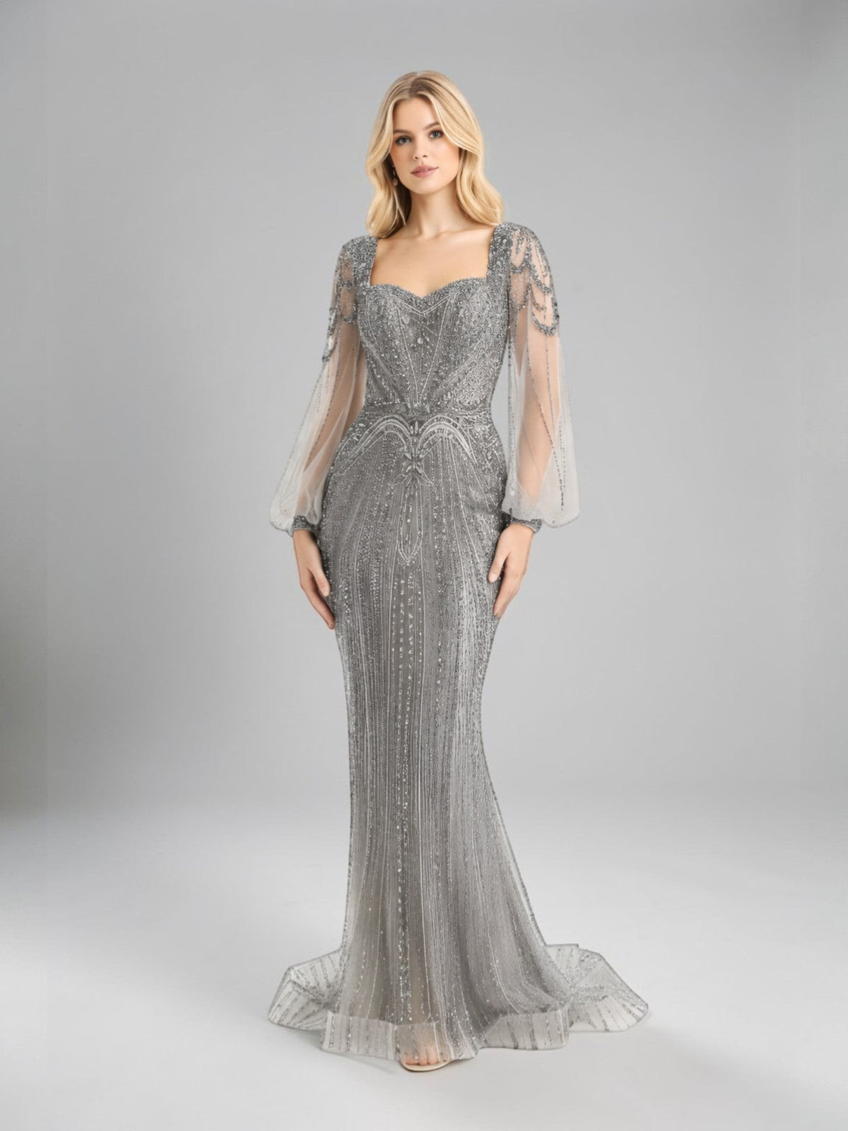 ALBANA New York silver tulle mermaid evening gown with rhinestone beading and sheer long sleeves on a model
