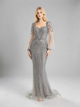 ALBANA New York silver tulle mermaid evening gown with rhinestone beading and sheer long sleeves on a model