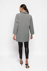 Back view of a model wearing an ALBANA New York textured geometric print collared jacket with black leather leggings.