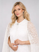 ALBANA New York white sheer maxi cape with rose embroidery, collar, and crystal button detail worn by a blonde model.